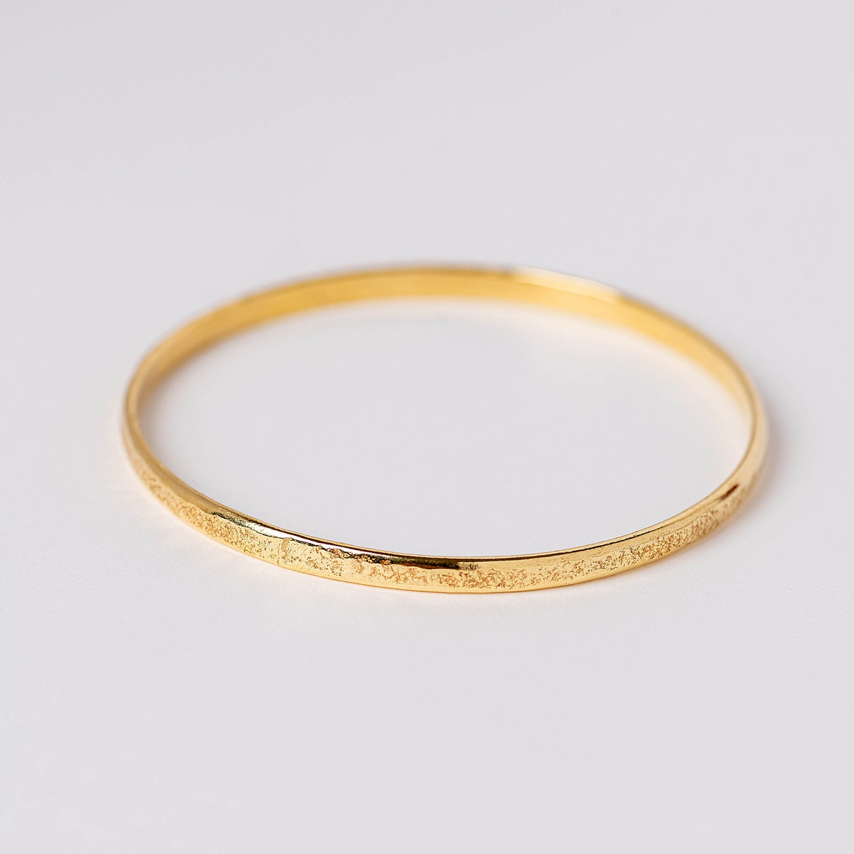 Pulsera rígida con textura de roca y baño de oro de INDIGO